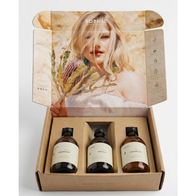 Set of three small bottles with labels in a cardboard box featuring a photo of a woman with flowers.